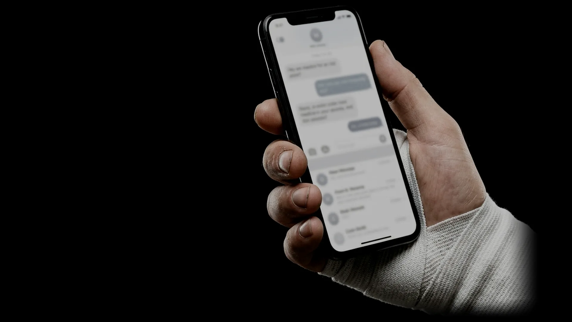 Una mano vendada sostiene un celular
